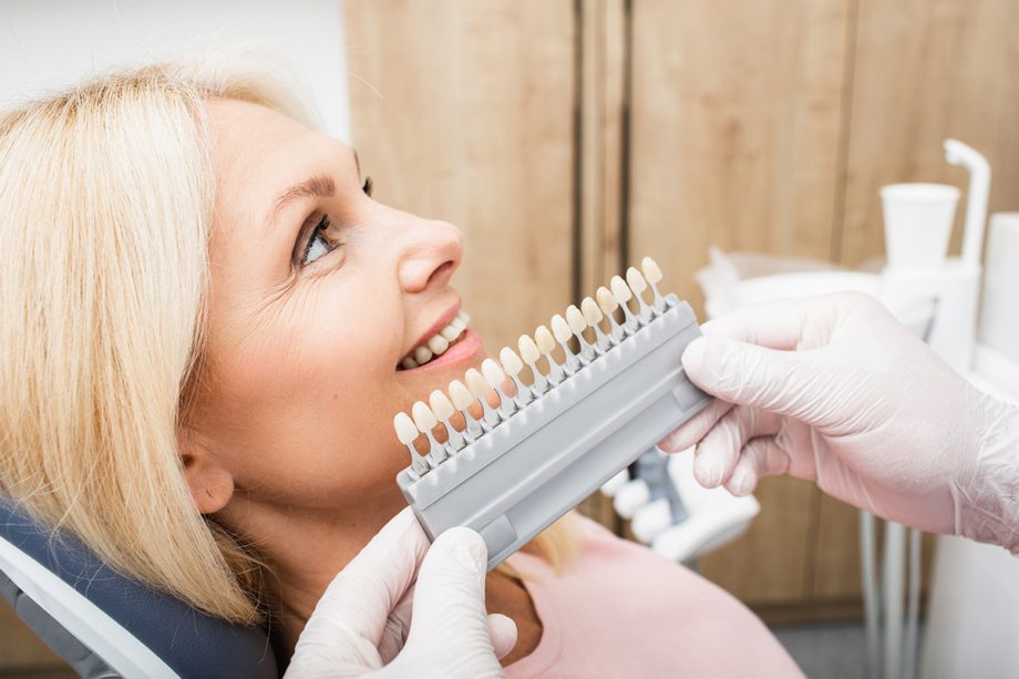 a dentist helps a patient pick veneers